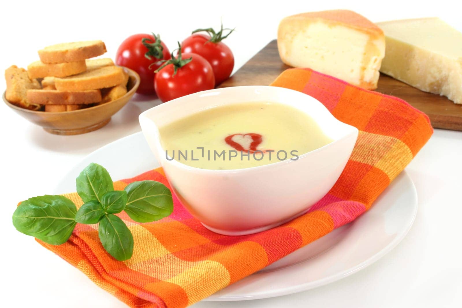 a bowl of cheese cream soup with croutons and basil