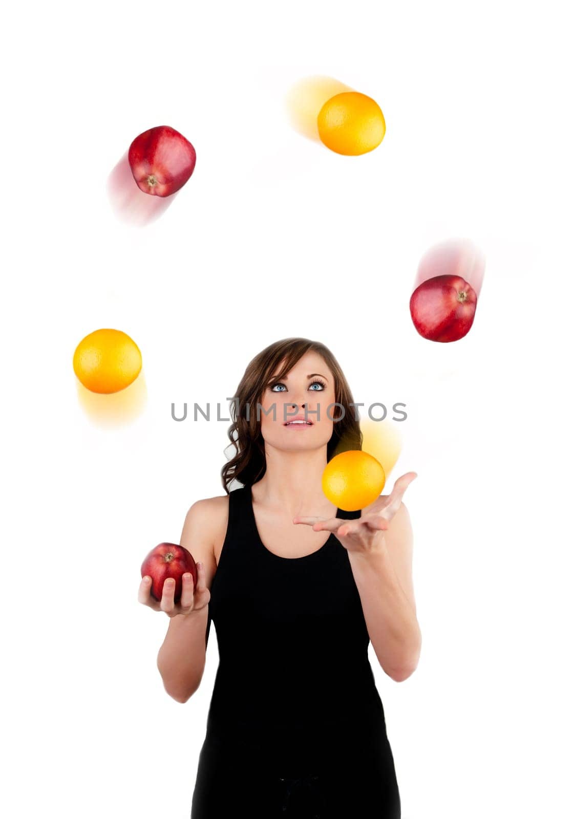 Beautiful woman juggling apples and oranges in motion a white background