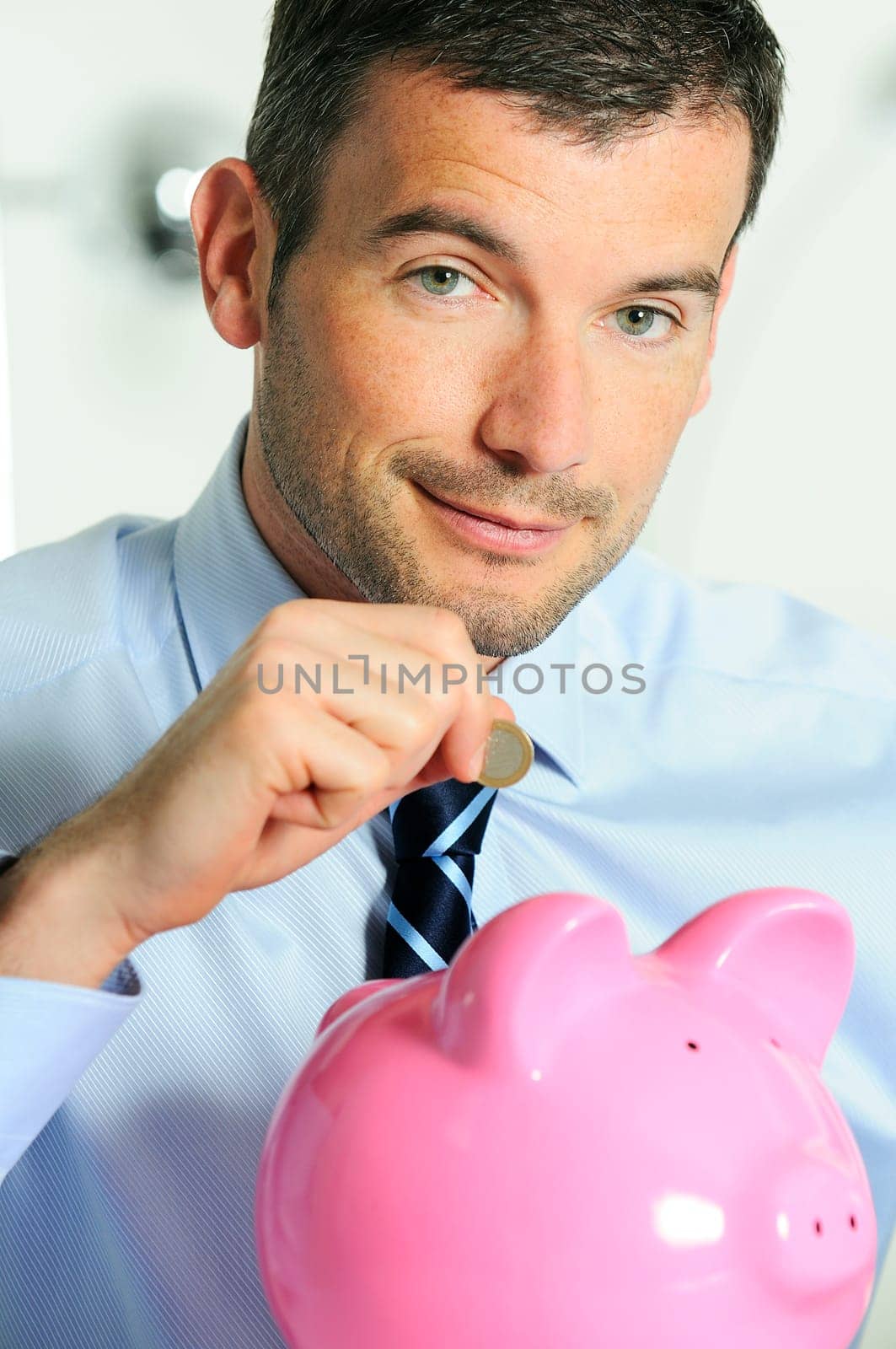 businessman matting a coin in the piggy-shaped pink pig