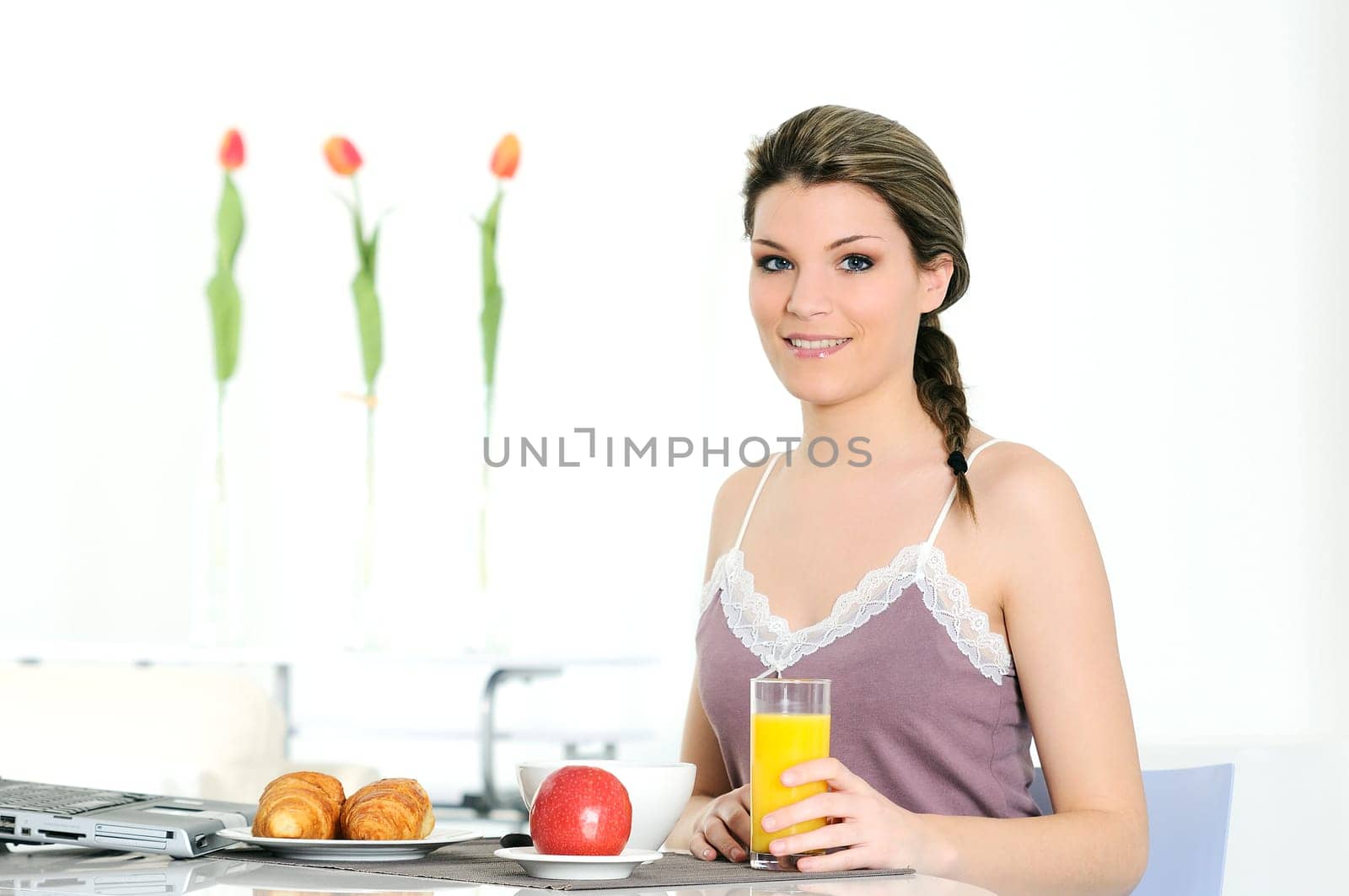 beautiful woman in bathrobe is having breakfast