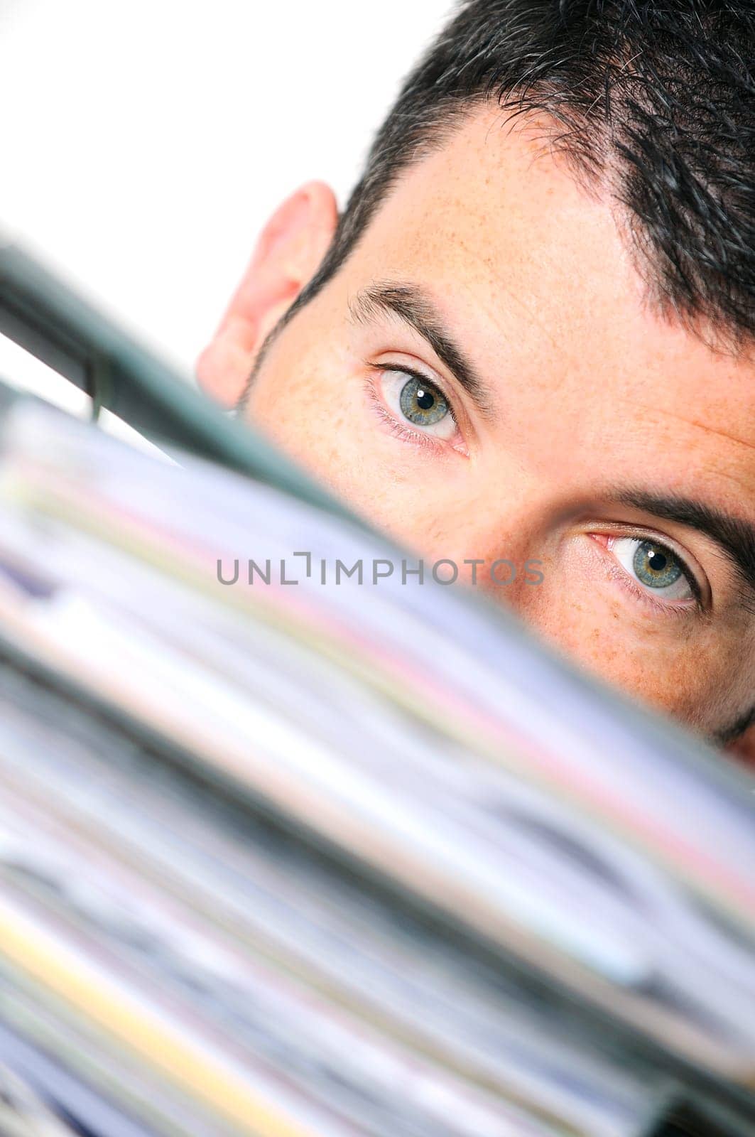 busy man hiding behind a stack of files