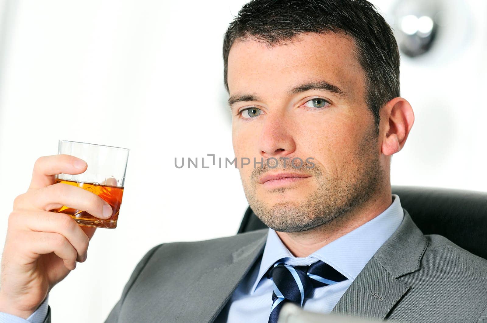 business man is drinking alchool at the office
