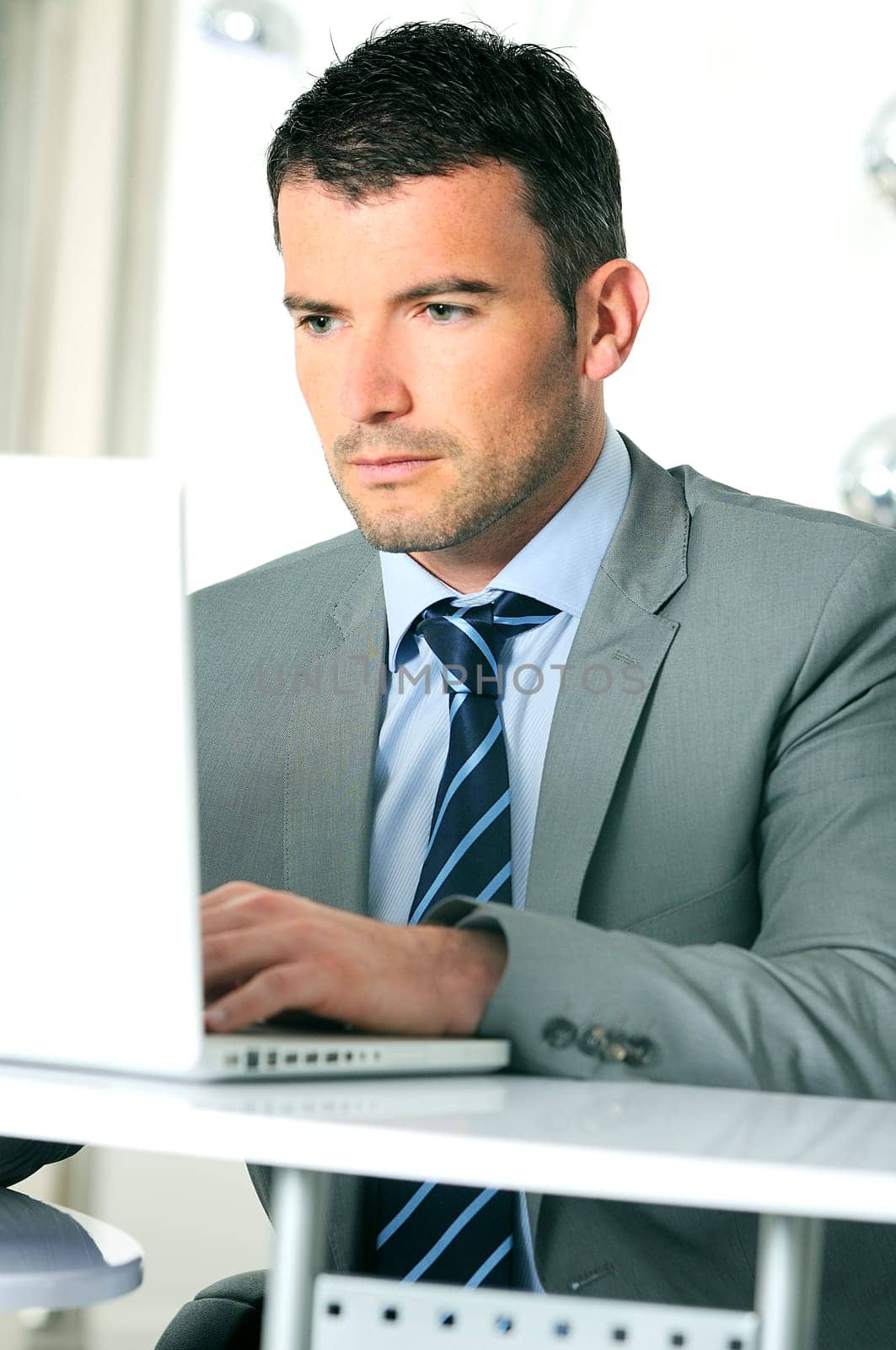 An attractive business man is working on computer