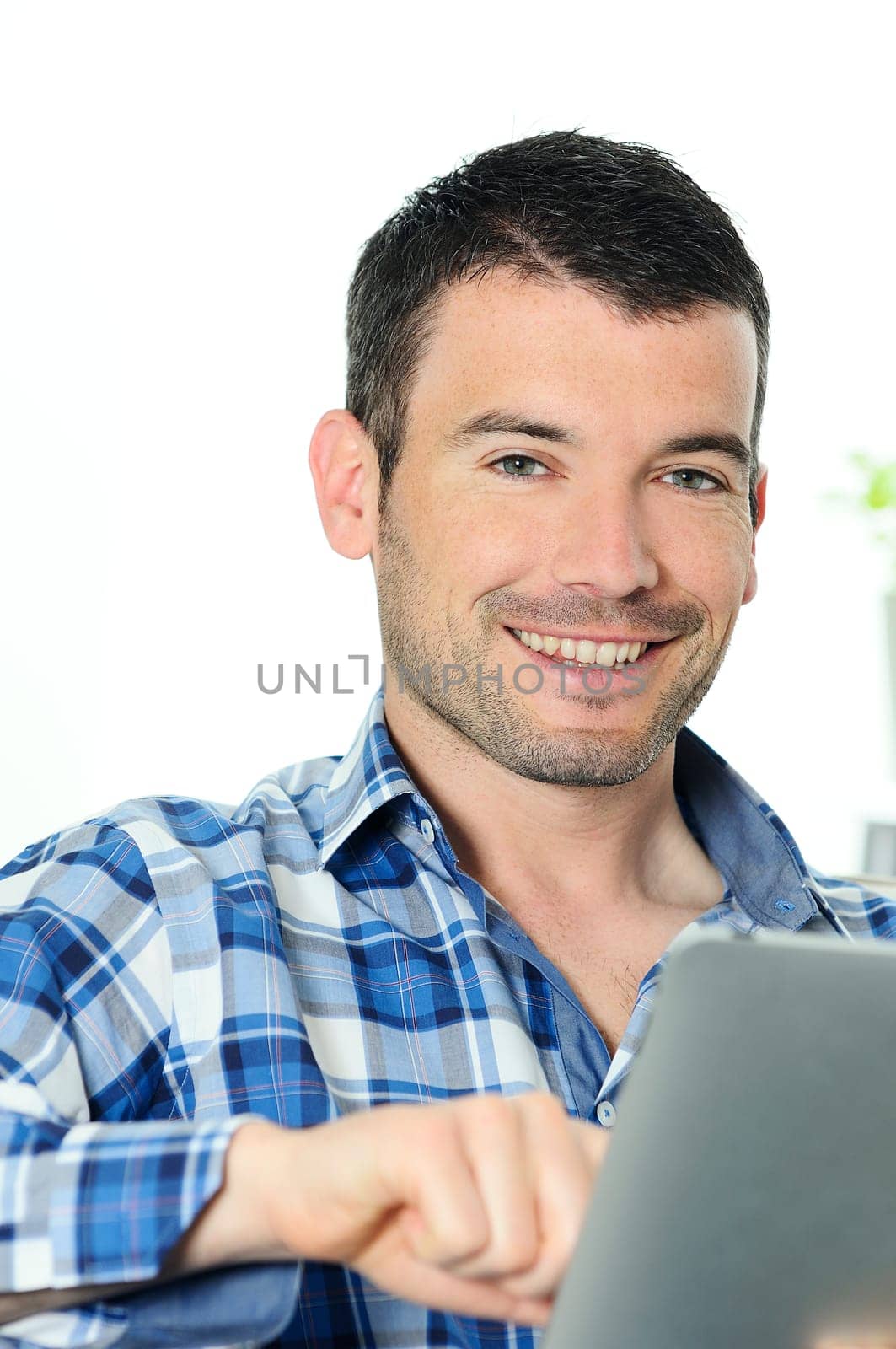 attractive relaxed and positive man is surfing on his tablet