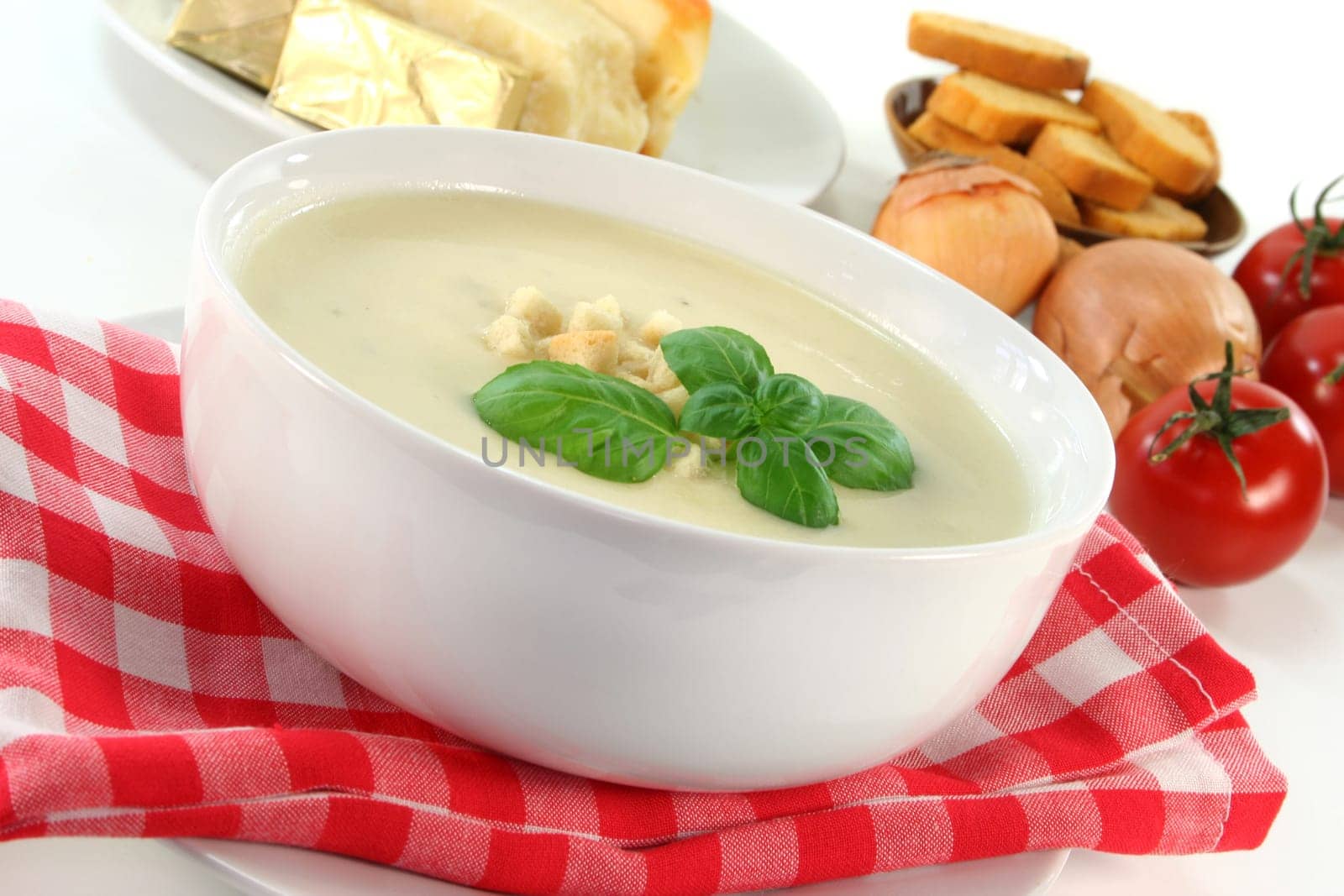 a bowl of cheese cream soup with croutons and basil