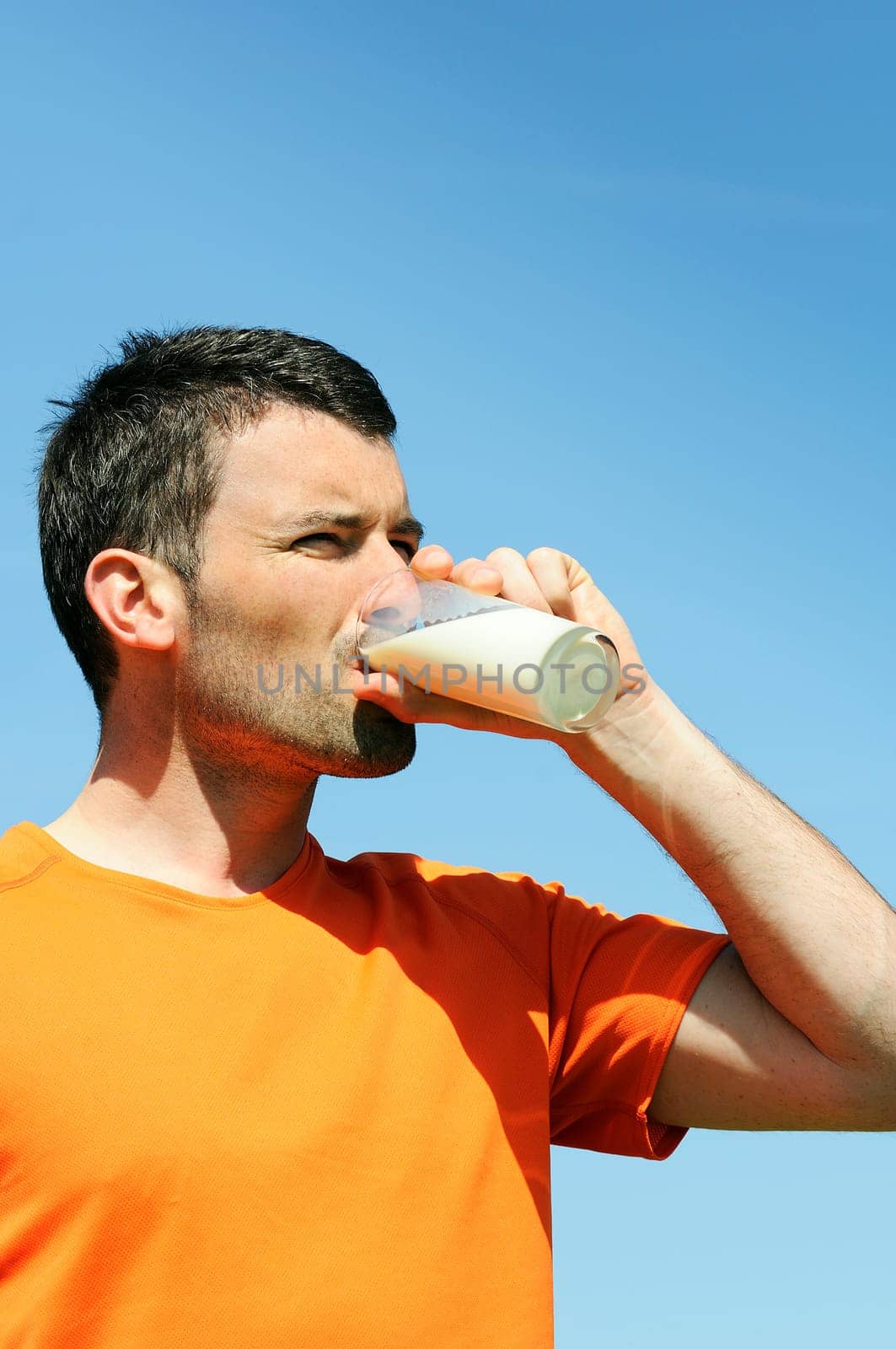 man is drinking fresh glass of milk in the blue skye
