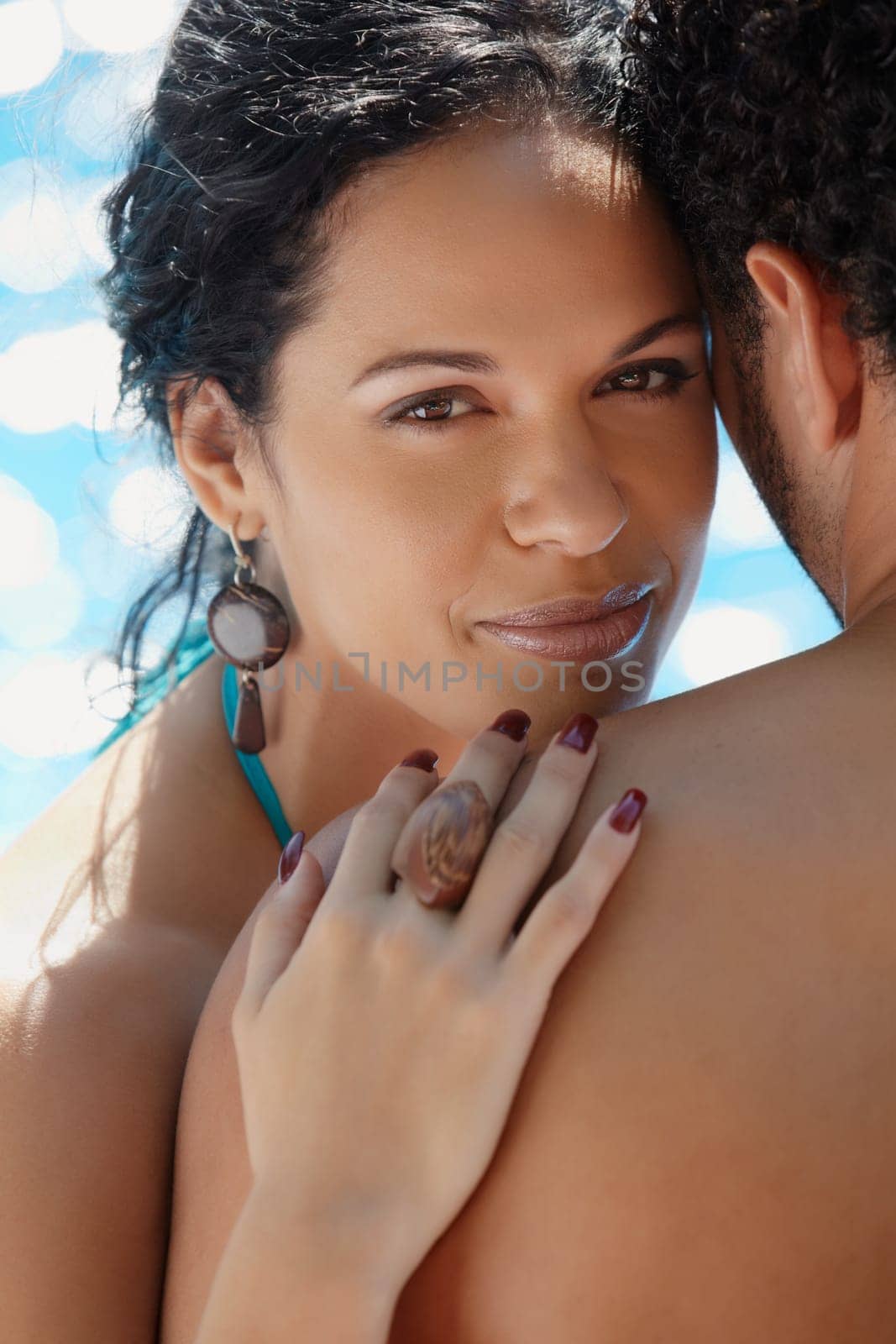 Honeymoon: happy young newlyweds smiling and relaxing near hotel pool. Vertical shape, head and shoulders