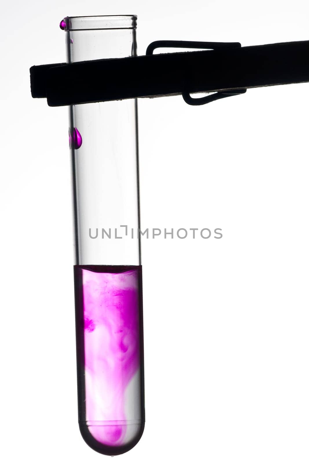 Test tube on clamp with violet liquid