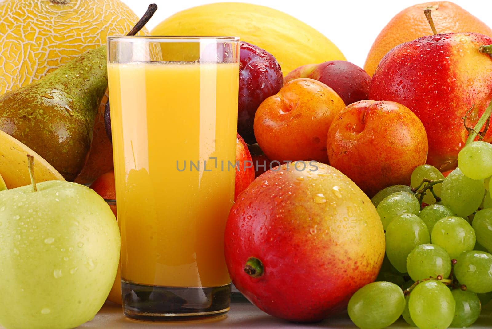 Composition with variety of fruits and glass of orange juice