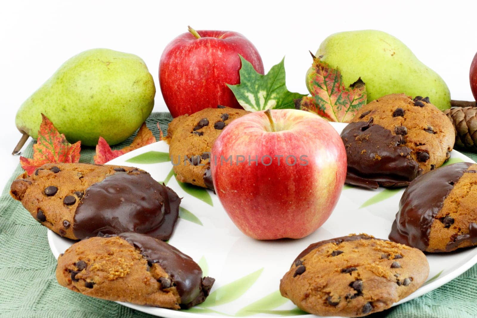 Fall treats dipped in chocolate surrounded by apples, pears, leaves, pine cone.