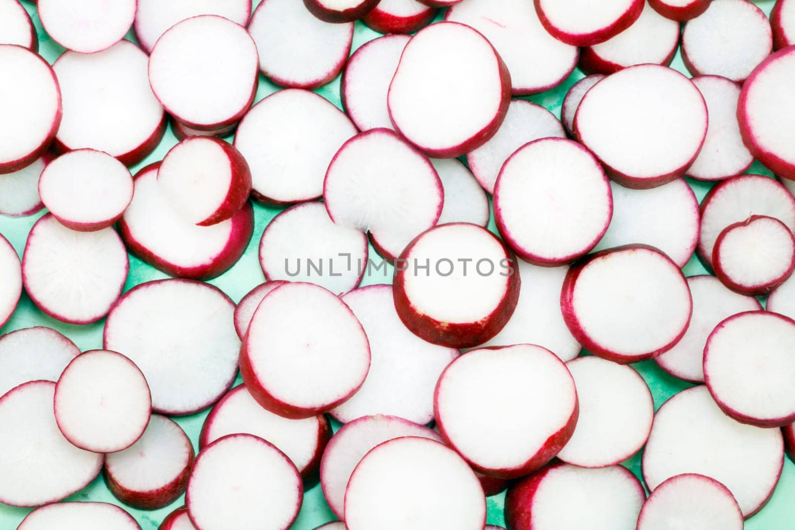 Slices of this delicious red and white vegetable are shown on a light green background.