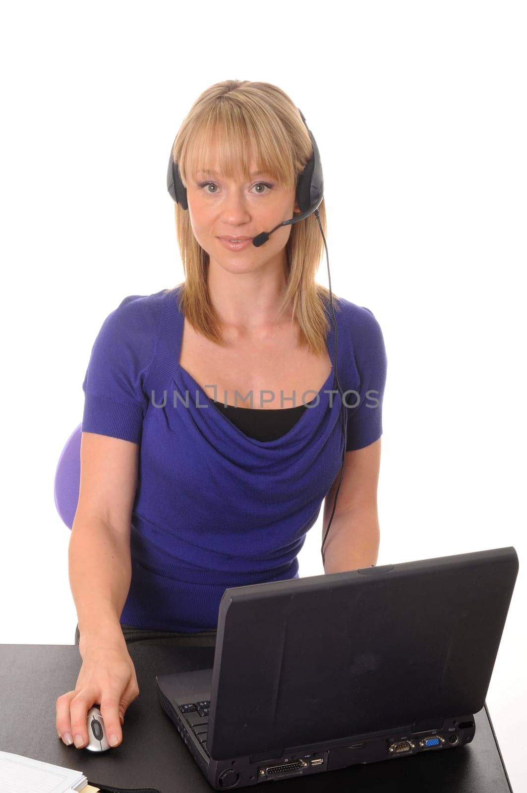 Young businesswoman wearing a headset and working on a laptop