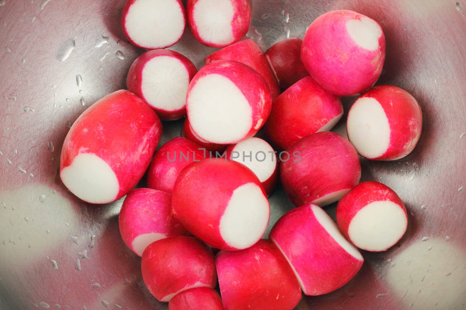 This wet, red root vegetable is without leaves or roots in a stainless steel bowl.