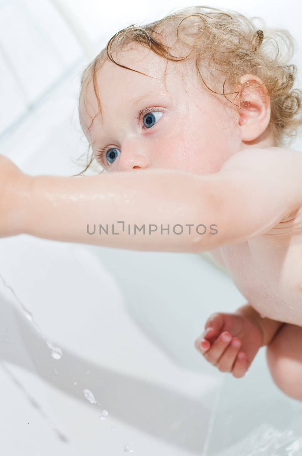 Toddler having fun bathing in the tub