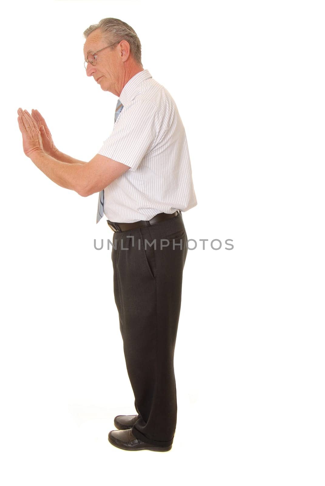 Senior businessman pushing against imaginary wall isolated over white
