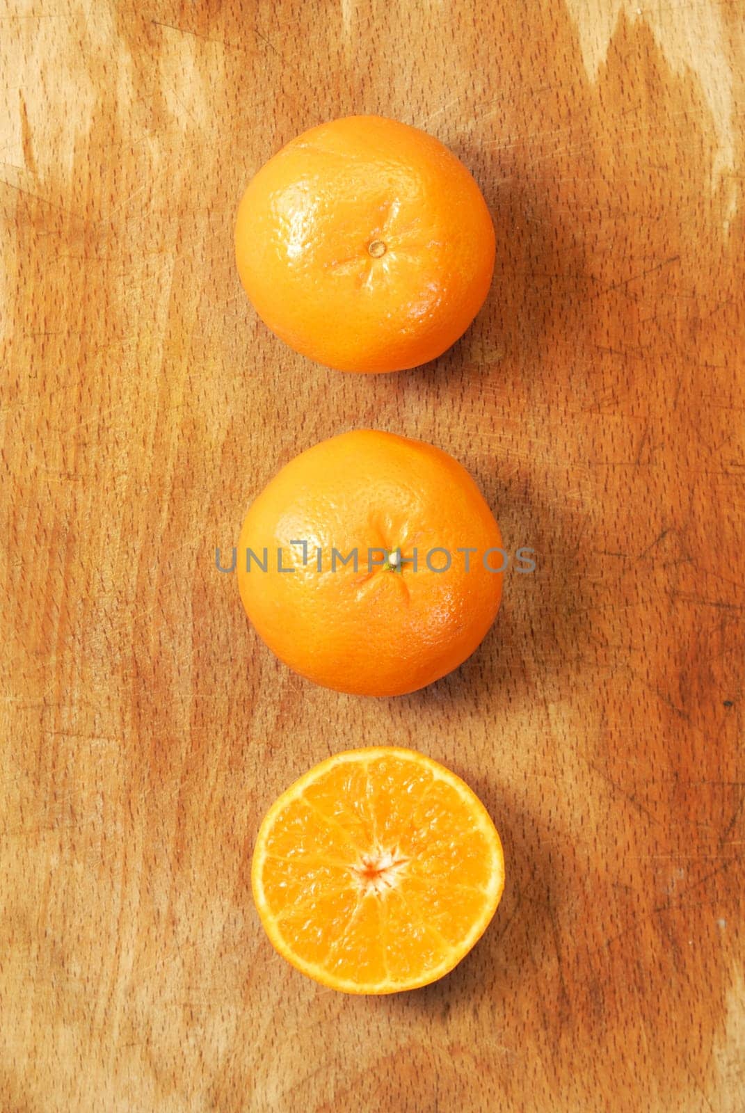 Half of orange and the whole orange. On wood background.