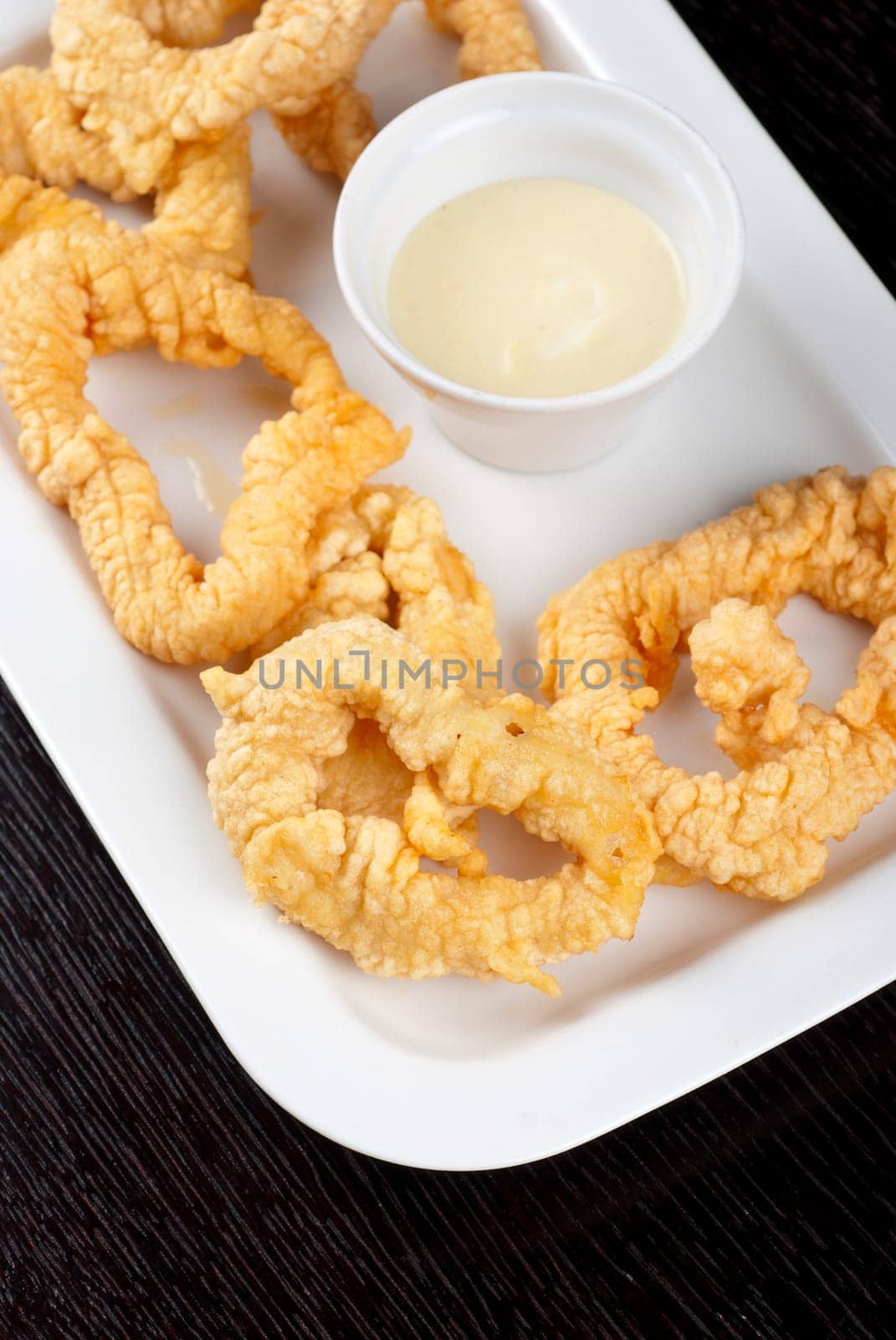 Deep-fried squid with sauce at white plate