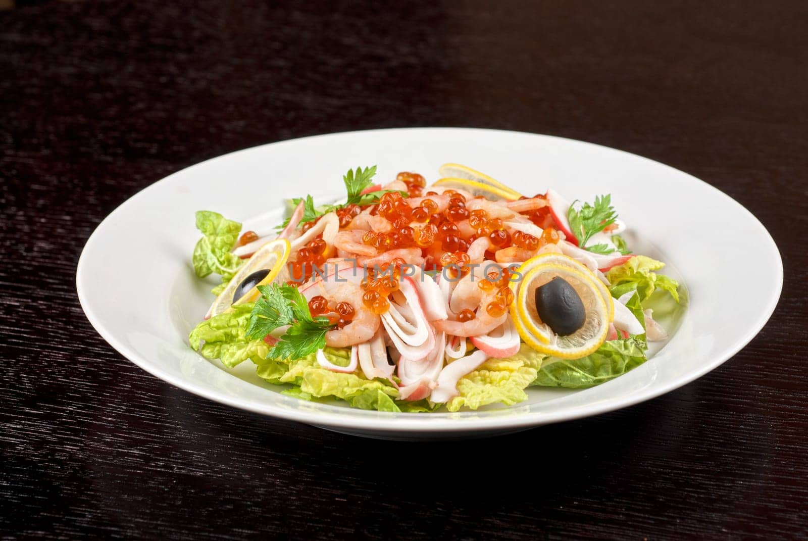 Salad with shrimps, caviar, calamaries, lettuce, lemon and olive