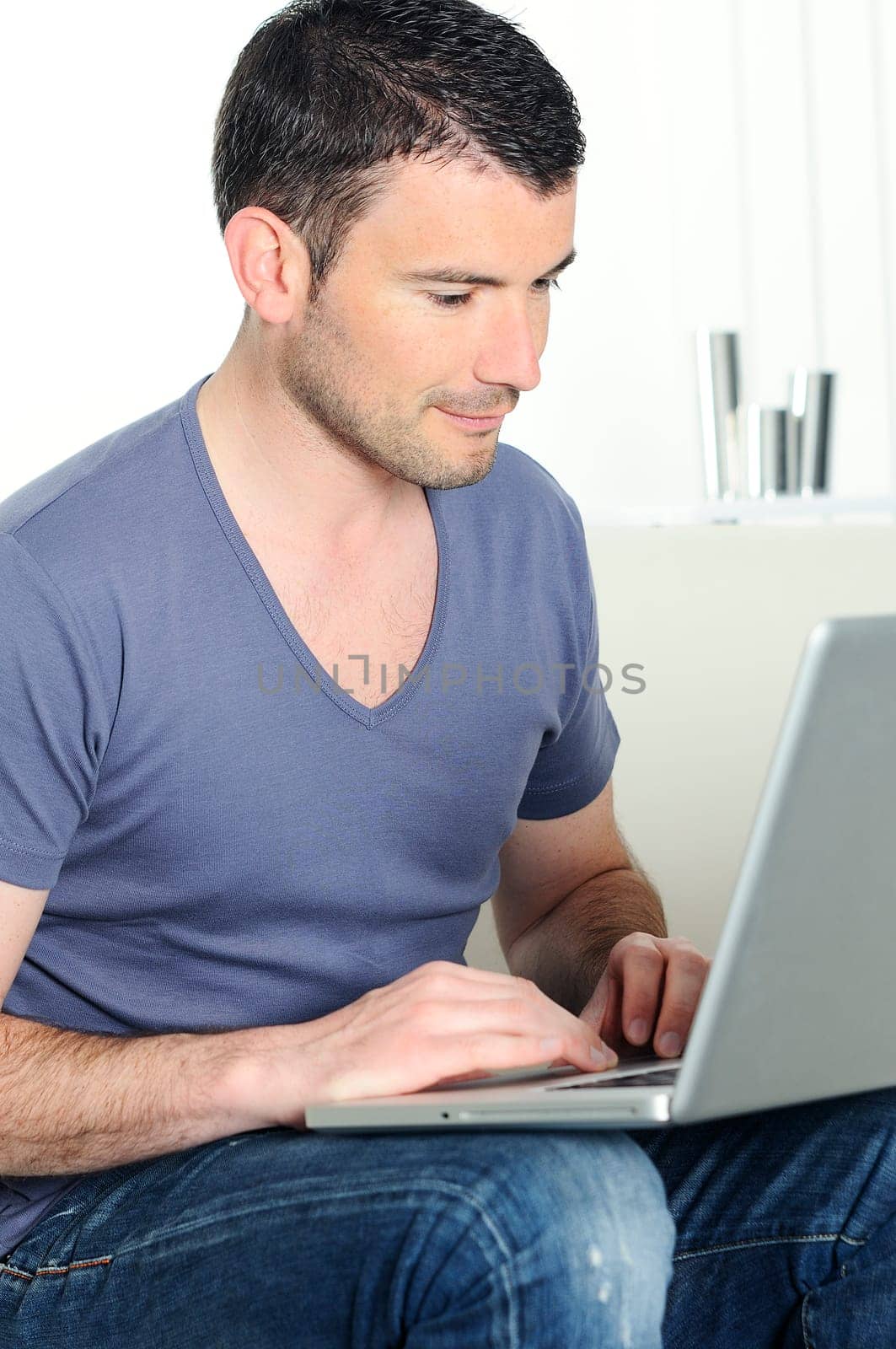 casual attractive man is surfing on web with his computer