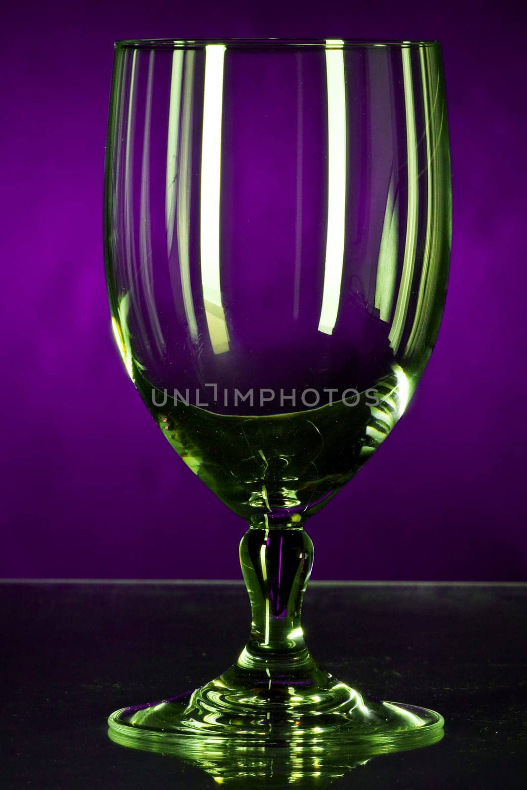 Empty glass shimmering in money against violet background