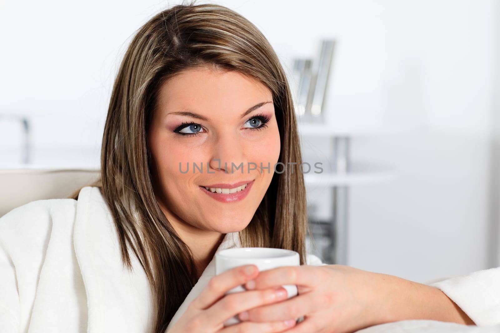 beautiful young woman on sofa with cup of coffee