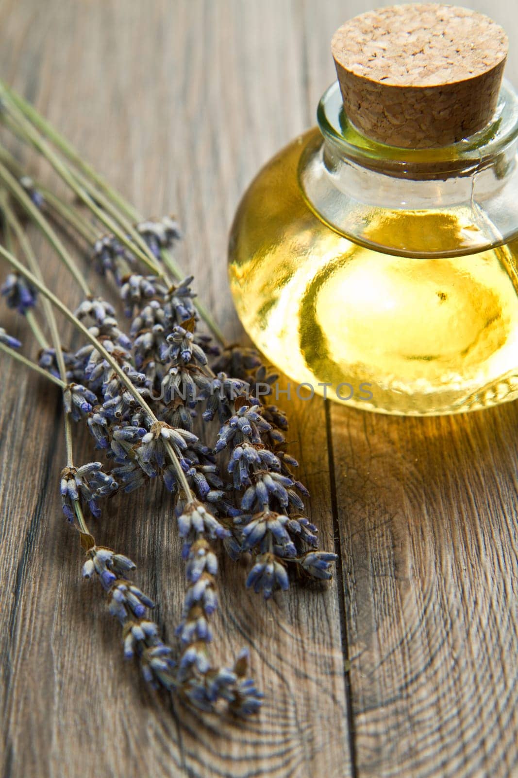 lavander oil with flowers on wooden table
