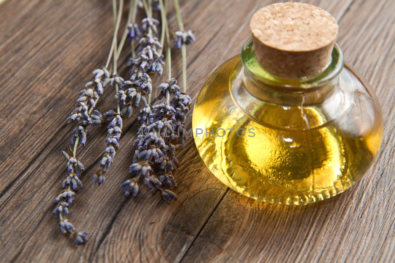 lavander oil with flowers on wooden table
