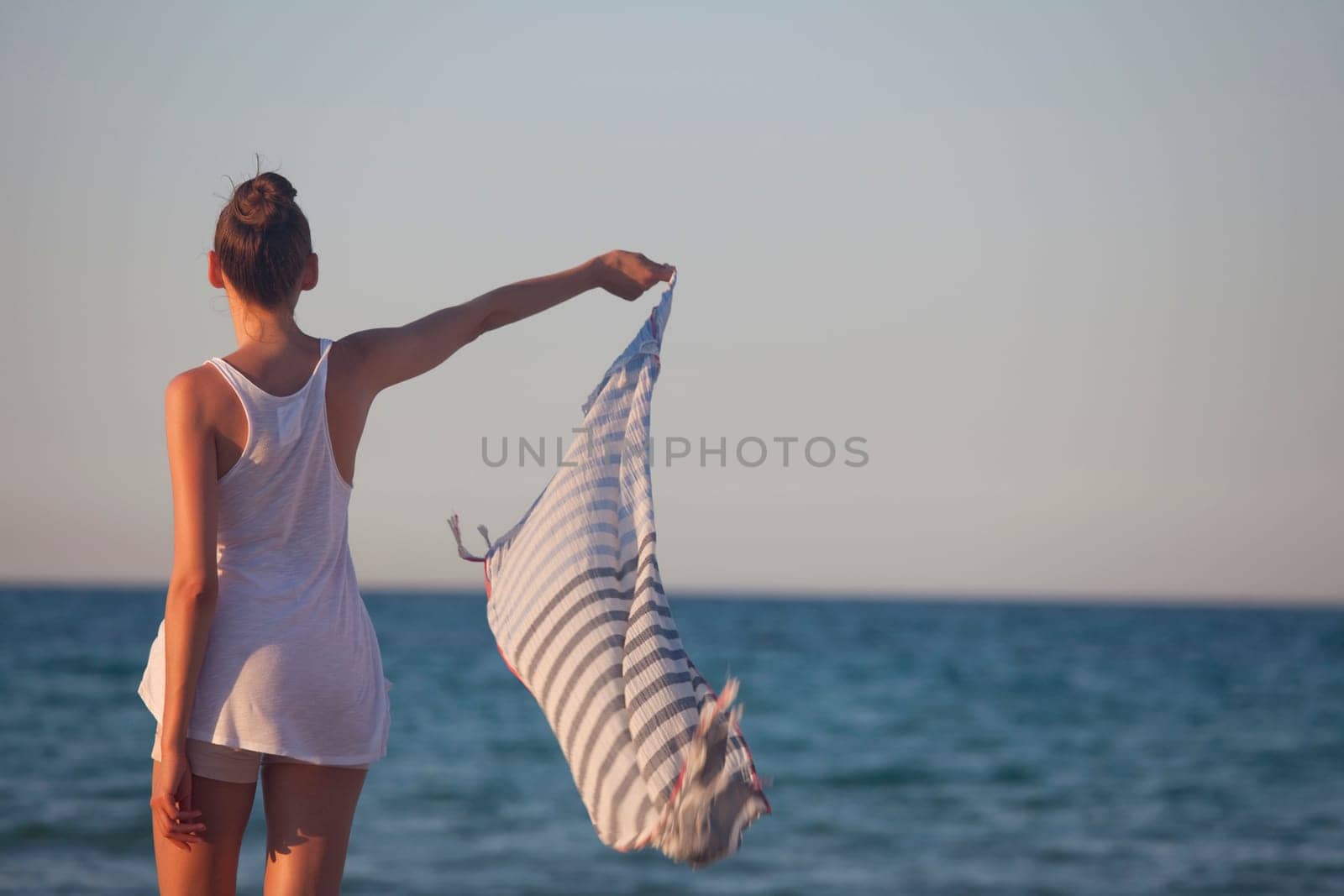 woman holding veil or scarf at the beach