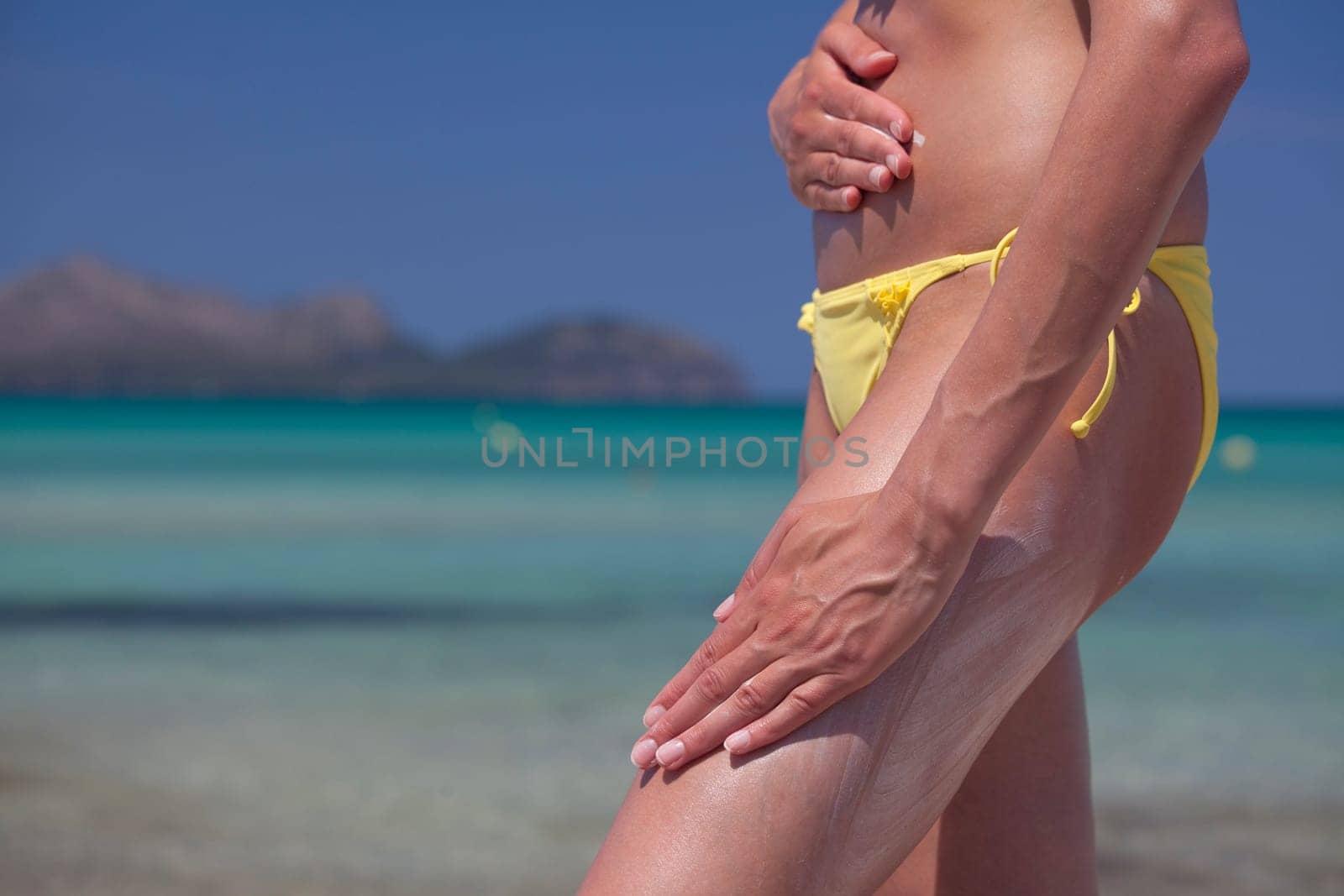 Woman applying suntan lotion at the beach