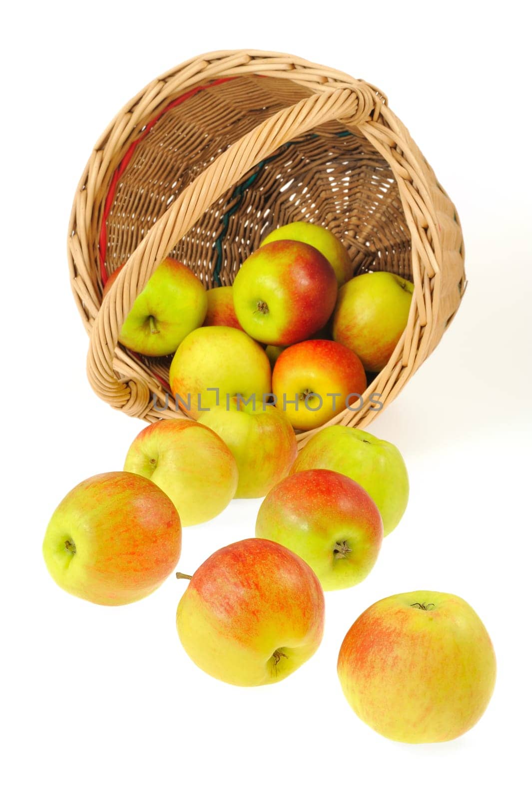 Fresh apples spilling out of basket - isolated on white background. Clipping path included.