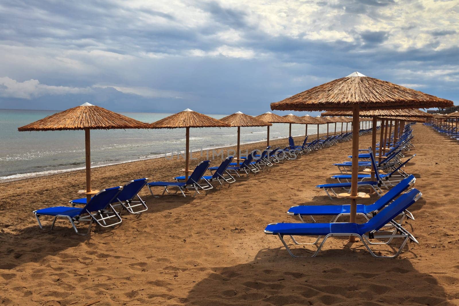 a beach filled with sun beds in Zakynthos, Greece
