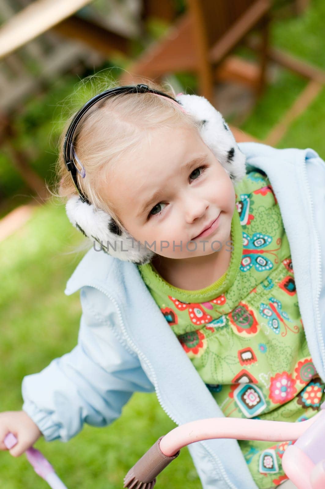 Shot of little girl in headphones playing outside