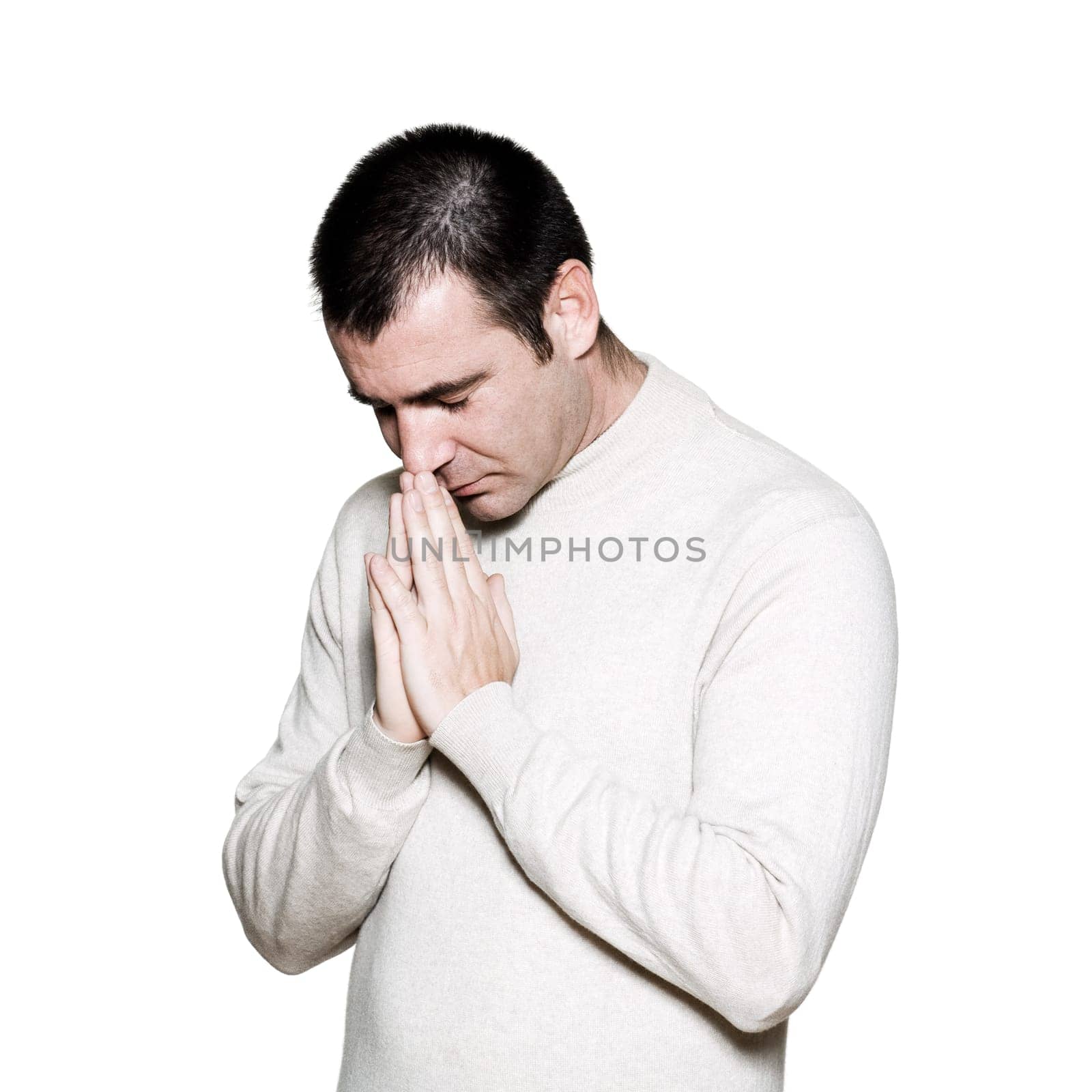 Portrait of a religious expressive man praying in studio on white isolated background