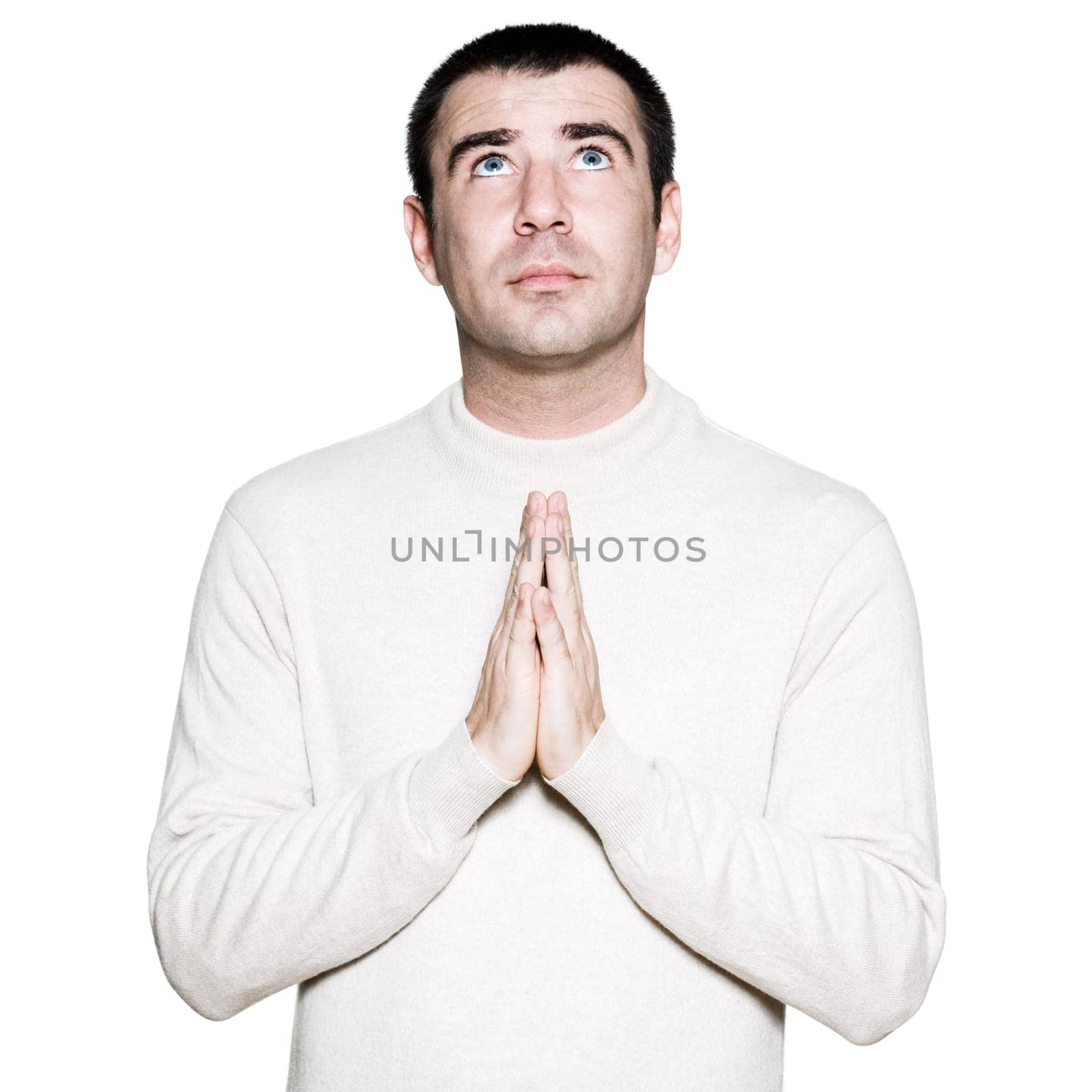 Portrait of a handsome man with hands clasped in prayer in studio on white isolated background