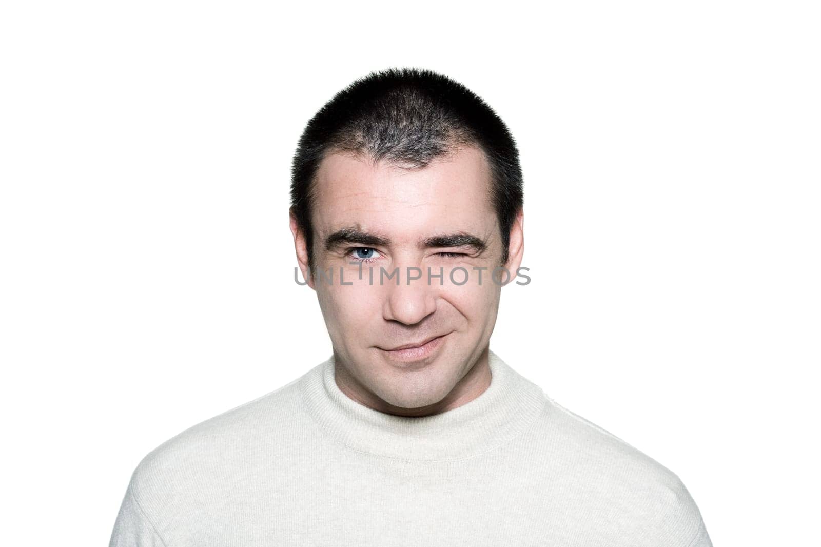 Portrait of a handsome cunning man winking in studio on white isolated background