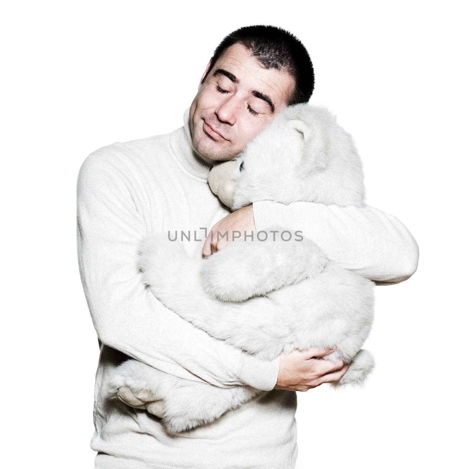 Portrait of an expressive man hugging a teddy bear in studio on white isolated background