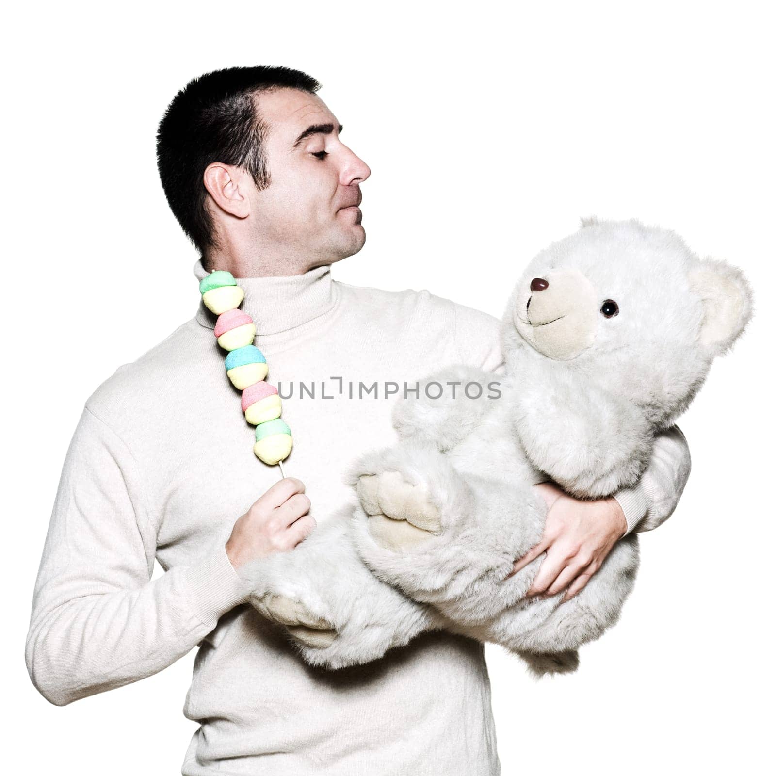 Portrait of a handsome expressive man with a toy and teddy bear in studio on white isolated background