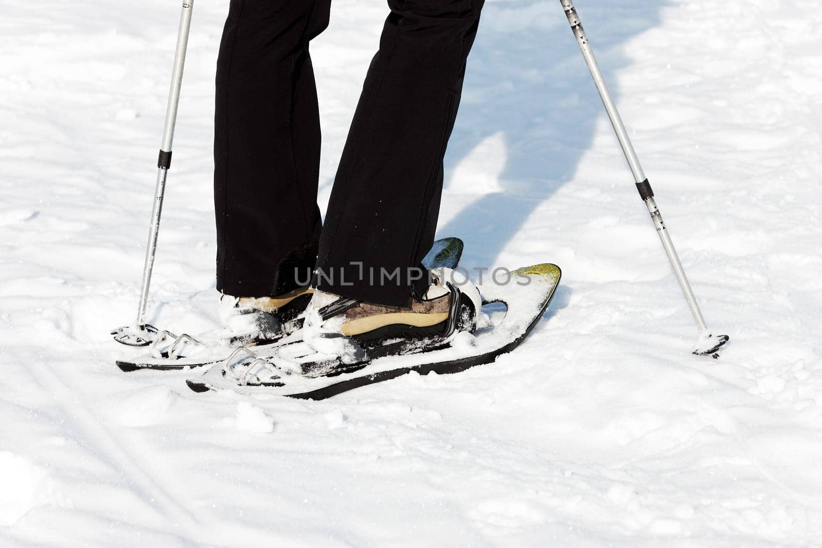 woman walking on the sow with rackets