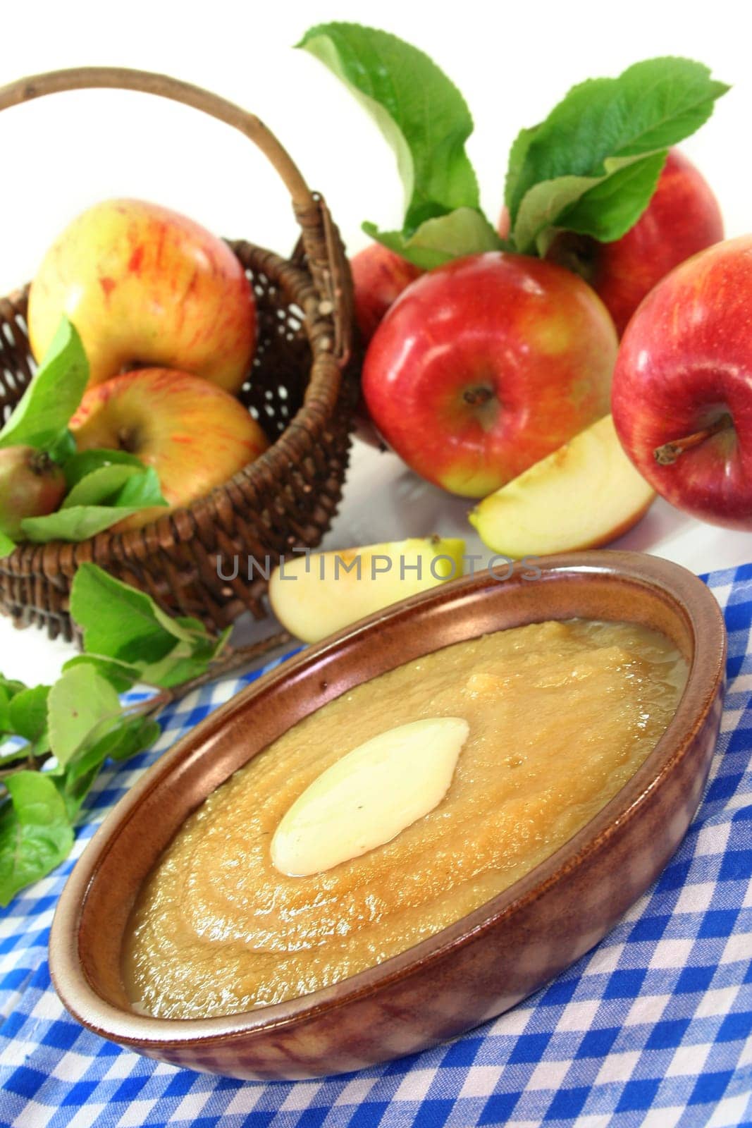 a bowl of applesauce with vanilla sauce and fresh apples