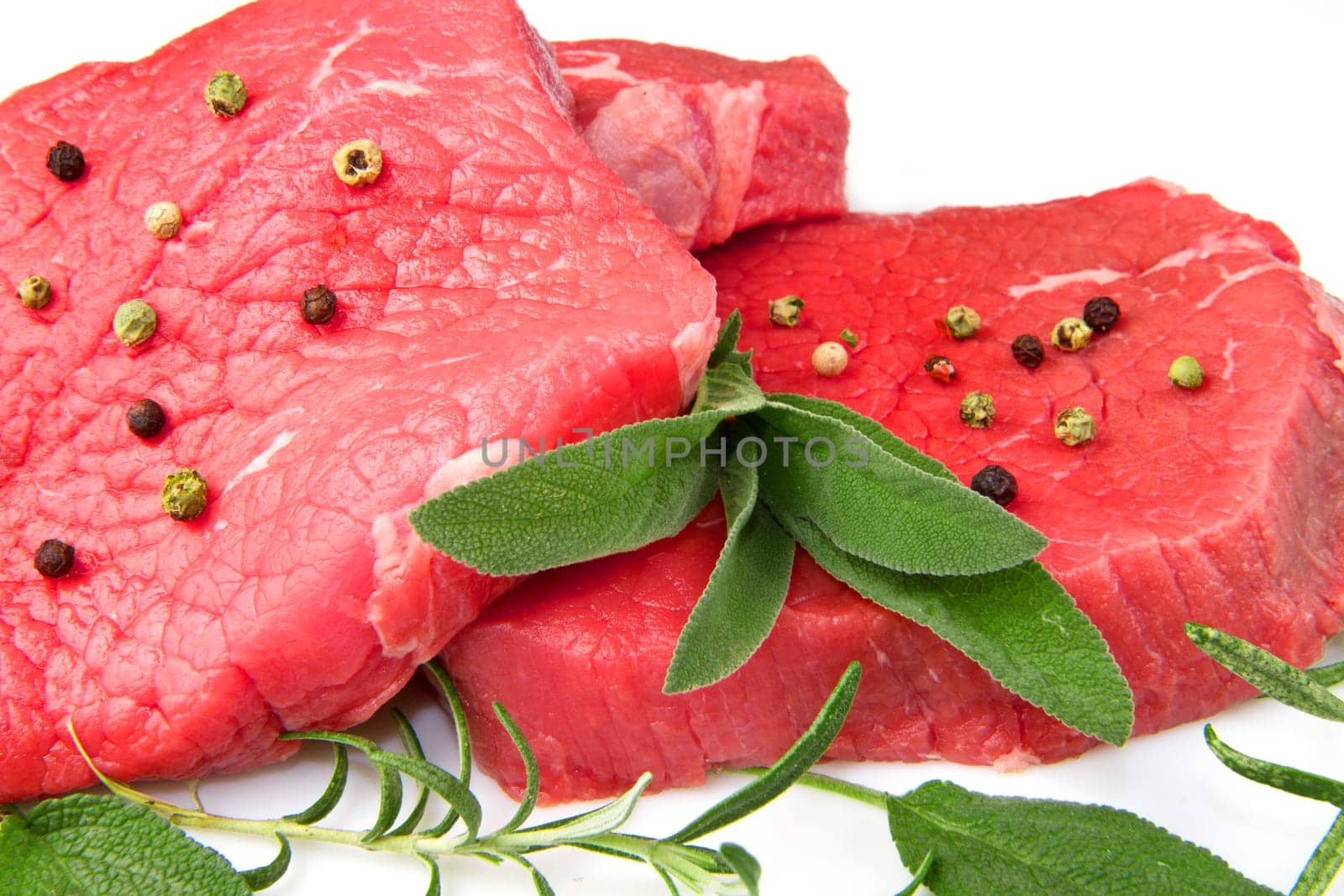 a red meat with sage and rosemary isolated on white background
