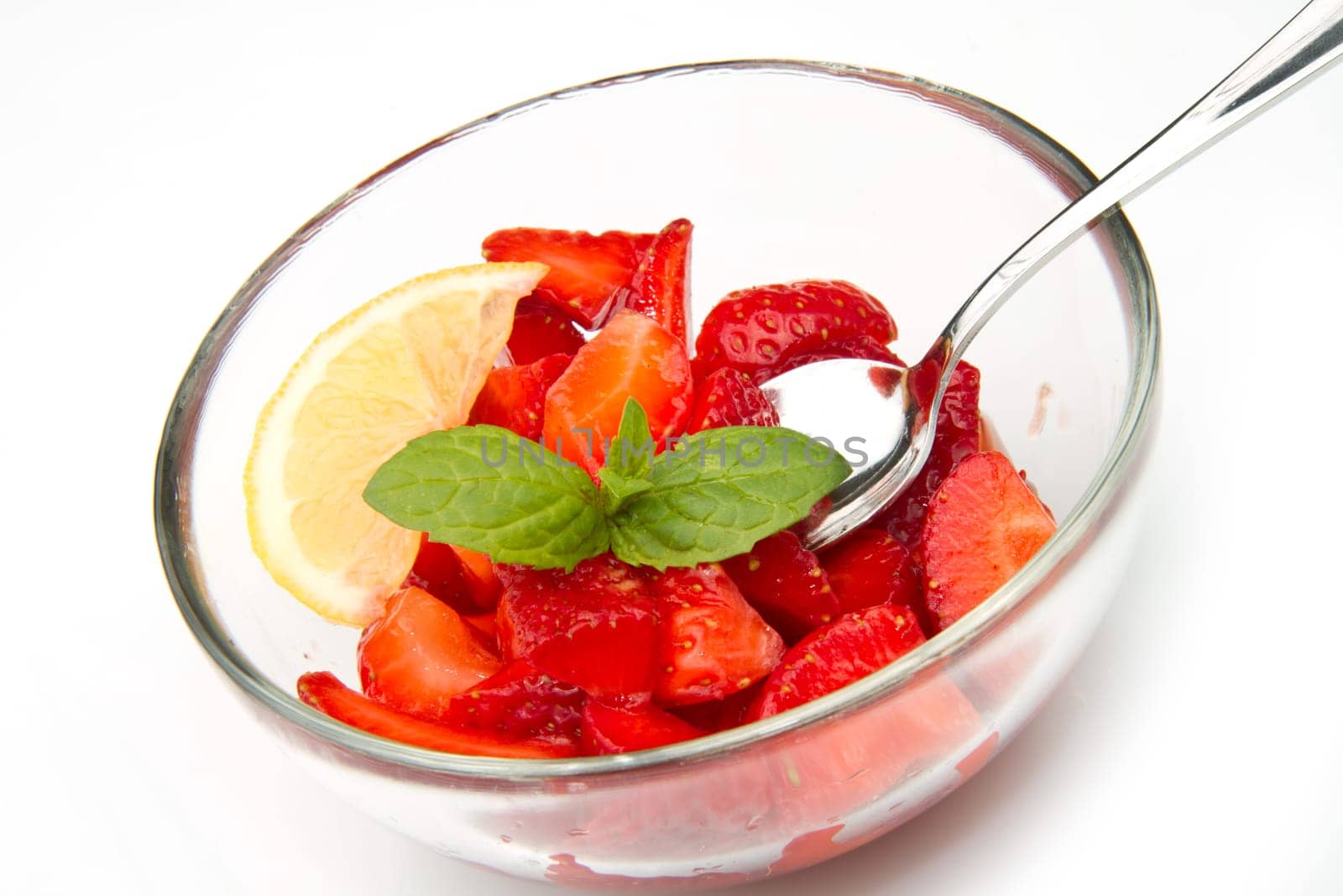 Strawberries in a cup decorated with a lemon on white background
