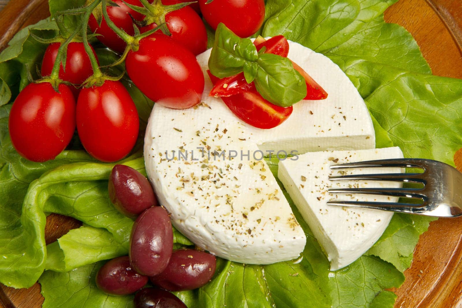 fresh cheese with salad, tomatoes and black olives