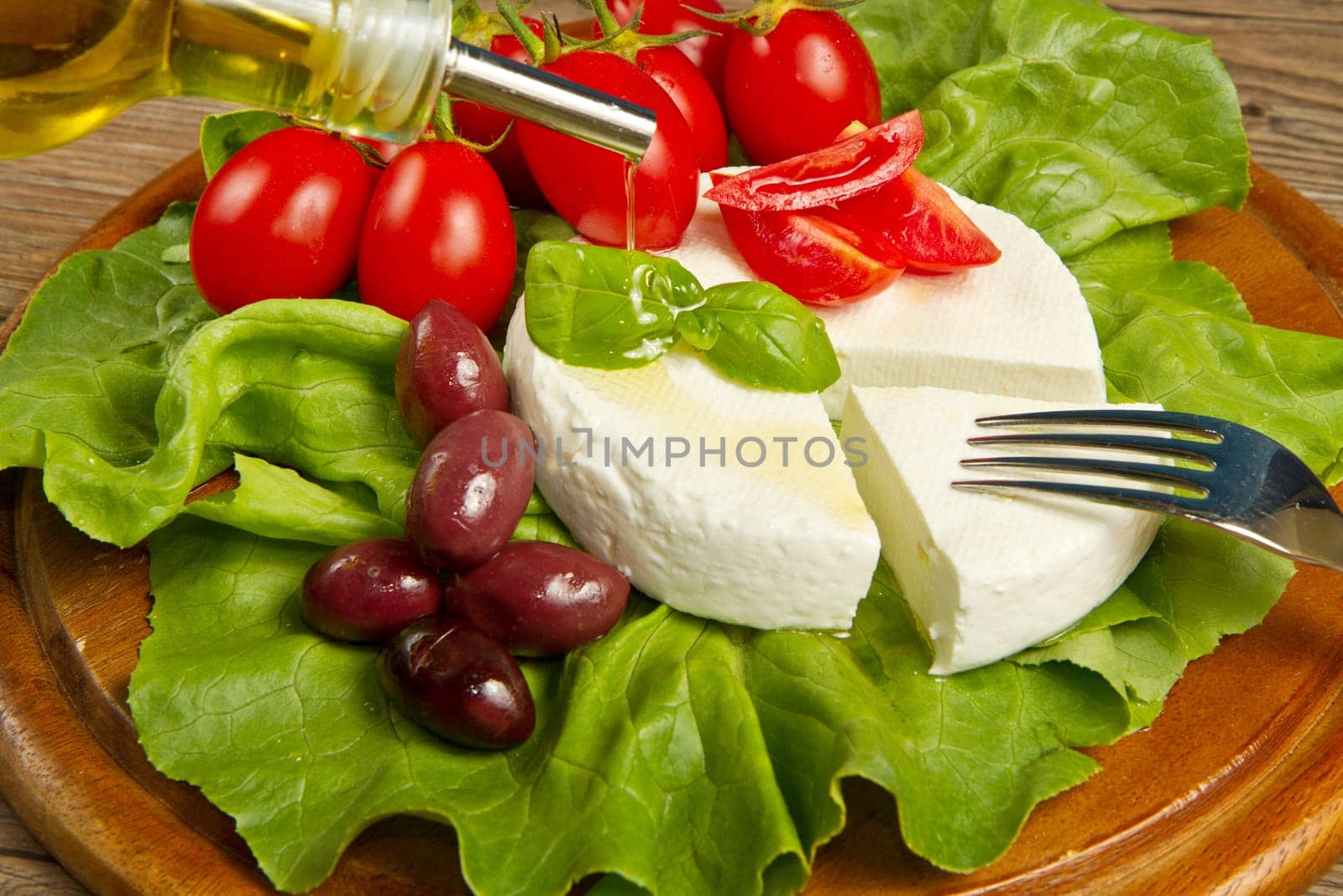 fresh cheese with salad, tomatoes and black olives
