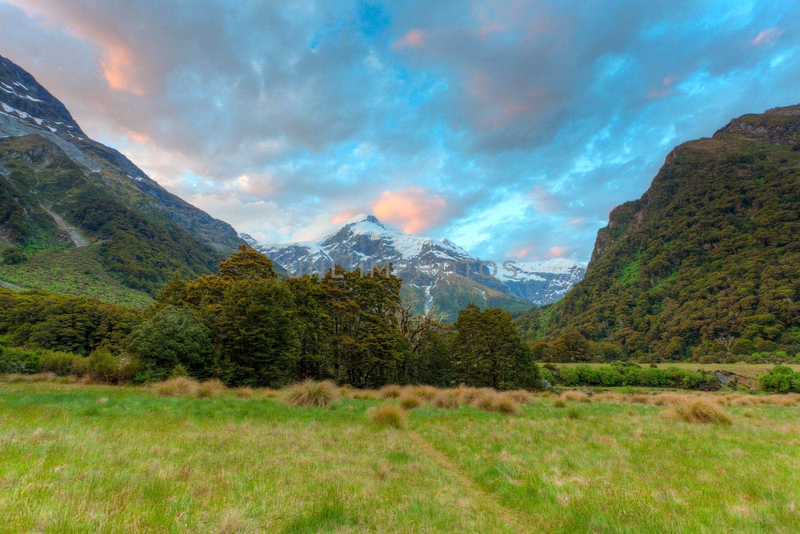 Sunset colors reflected on clouds over a New Zealand alpine valley