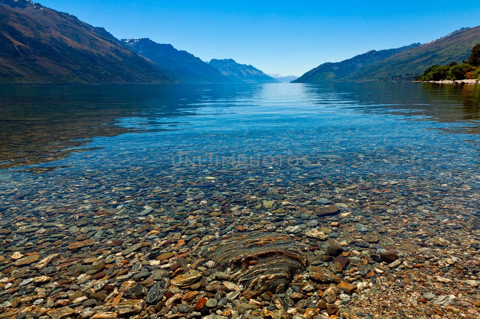 View of the clear waters and mountains at lake Wakatipu, New Zealand