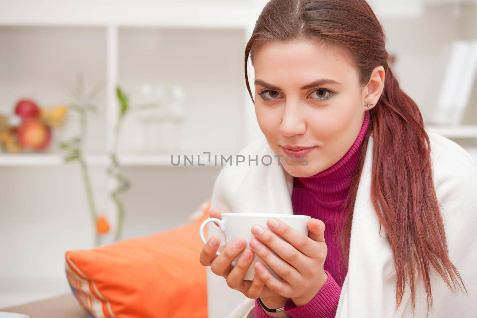 relaxed young woman at home with cup tea in her hands