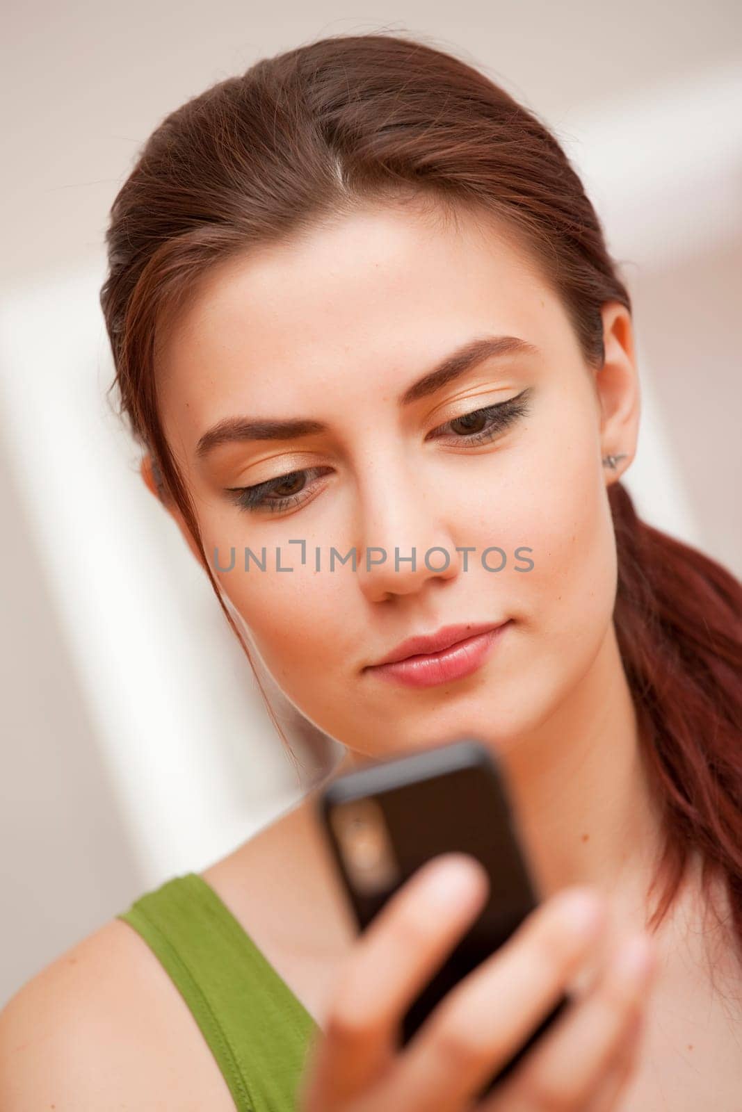 young woman holding cellphone reading a message