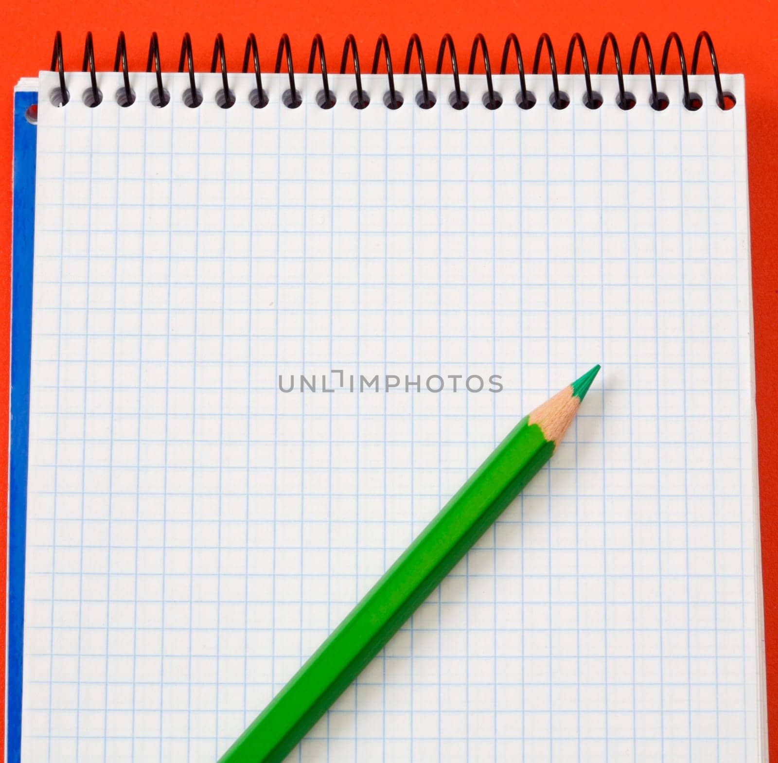 pencil and notebook over a red background