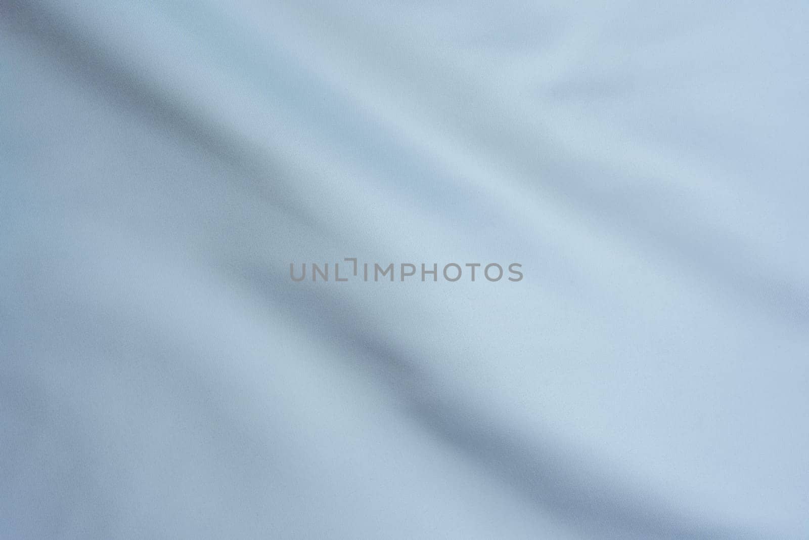 Close-up of white fabric with delicate folds, creating a minimalistic and elegant background suitable for design, textiles, and artistic projects.