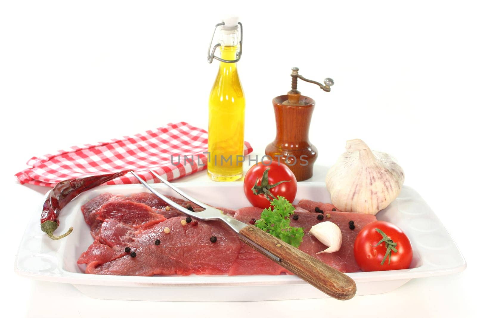 two raw pork steaks on a white serving platter